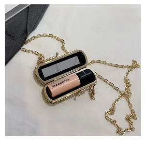 Detail of gold rhinestone mini evening bag featuring interior mirror and lipstick storage