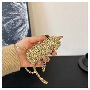 Detailed view of hand-held capsule evening bag with white rhinestones and gold chain