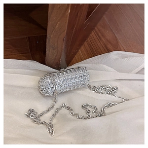 Detailed view of silver rhinestone pill-shaped clutch with elegant metal chain strap
