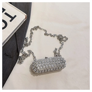 Close-up of a mini cylindrical evening bag with silver rhinestones and large chain strap