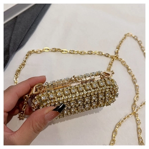 Detail of a sparkling cylindrical rhinestone mini bag with a fine gold chain strap