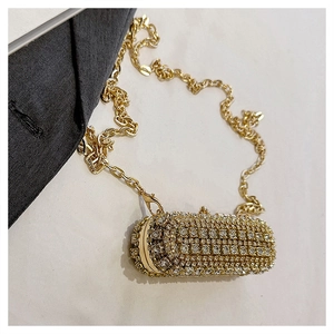 Detailed macro view of the sparkling rhinestone surface and golden chain strap of the bag