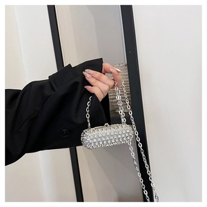 Macro shot of silver rhinestone capsule clutch bag with metallic chain strap detail