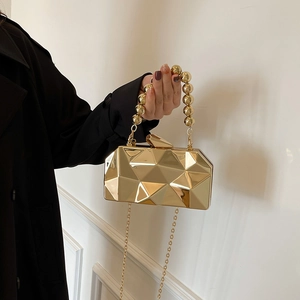 Metallic gold evening clutch bag with geometric faceted design and beaded top handle