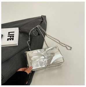 Dettaglio della borsa da sera in acrilico argento con texture metallo liquido
