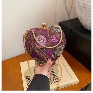 Detail of heart-shaped evening bag with purple sequins and crystal clasp