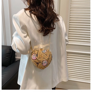 Macro shot of heart-shaped evening bag with gold sequins and floral bead embroidery