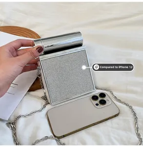 Silver metallic crossbody bag size comparison with an iPhone 12 for scale