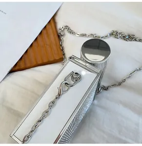 Detailed close-up of a silver perfume bottle shaped chain bag with sparkling rhinestones