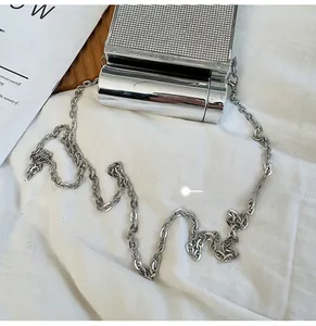 Detail of silver metallic purse with rhinestone inlay and sleek chain shoulder strap