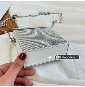 Detailed bottom view of a white rhinestone evening bag with elegant silver metal frame