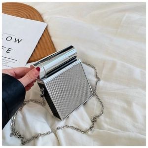 Macro detail of silver box clutch featuring rhinestone surface and a metal tube handle