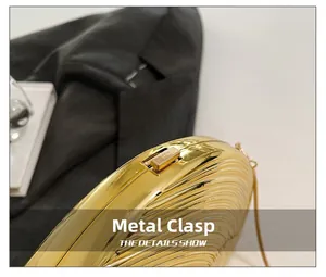 Close-up of golden conch clutch with wavy texture and hardware clasp detail