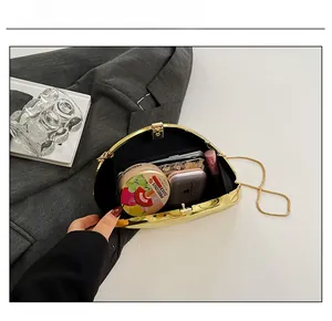 Internal capacity of shell evening clutch bag showing phone and makeup accessories