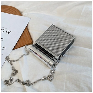 Detail of silver rhinestone evening bag with chain strap on a white draped background