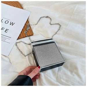 Detailed view of silver mesh rhinestone box bag with metal frame and delicate chain strap