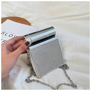 Close-up of a silver rhinestone evening bag with cylindrical metal handle and chain strap