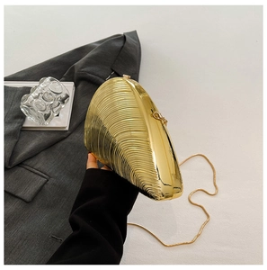 Detail view of the metallic conch evening clutch bag with golden chain and spiral texture