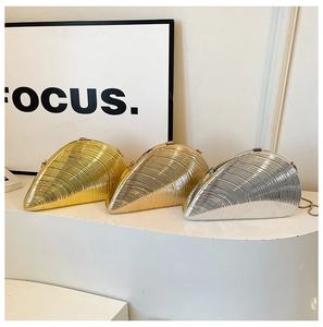 Detailed view of three metallic conch-shaped evening clutch bags with chain straps