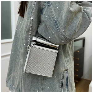 Close-up of a silver rhinestone dinner clutch bag paired with a stylish denim jacket