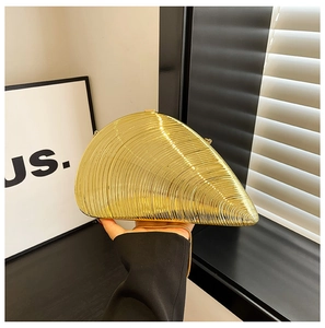 Macro shot of gold metallic shell-shaped evening bag with a sleek chain strap