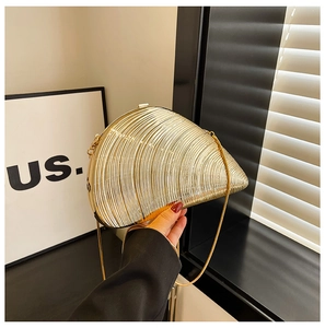 Detailed view of the gold shell-shaped evening clutch with elegant radial texture and chain