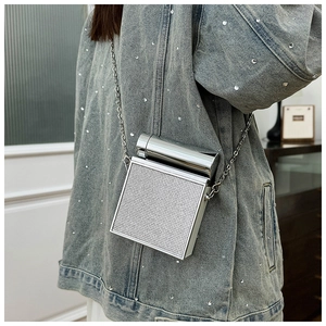 Detail of silver rhinestone evening bag with metal handle and elegant chain strap