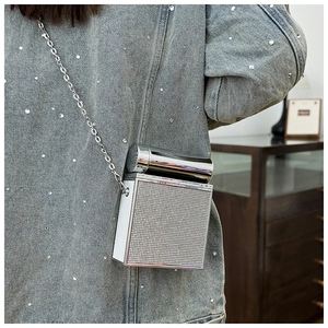 Detail of silver rhinestone evening bag featuring a unique metal handle and chain strap