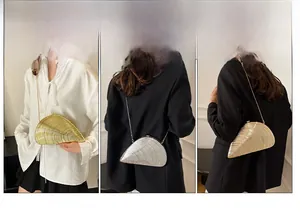 Three metallic conch-shaped evening bags in gold, silver and champagne with chain straps