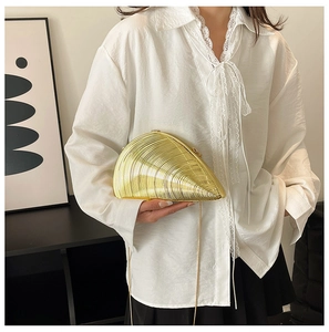 Golden conch shell clutch with radiating texture and elegant chain strap for evening events