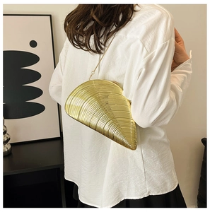 Elegant gold seashell clutch bag with fine ribbed texture and metallic chain strap