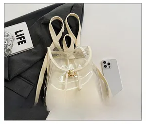 Detailed view of a transparent PVC backpack with cream leather trim and drawstring closure