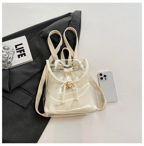 Detail view of transparent PVC backpack with cream inner pouch and metal buckle closure