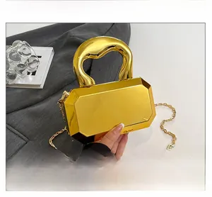 Macro shot of geometric gold acrylic clutch with chunky integrated handle and chain strap