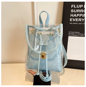 Detail of transparent PVC backpack with a blue drawstring pouch and gold metal twist lock