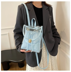 Detail showing light blue transparent PVC backpack with a drawstring inner pouch and gold clasp