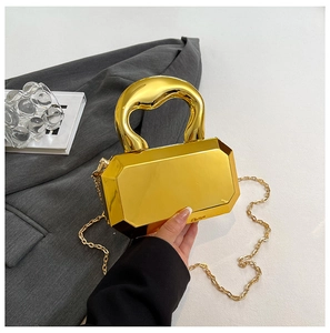 Close-up of gold mirror acrylic box bag with chunky chain and faceted gem-like surface