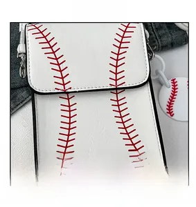 Detailed view of white leather crossbody bag with red baseball stitching and round charm