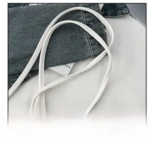 Close-up of white leather shoulder strap with metallic buckle for a transparent bag