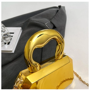 Macro shot of gold mirror acrylic evening bag with chunky handle and chain strap