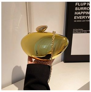 Detail of gold mango-shaped acrylic clutch bag with metal chain and top knob clasp