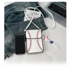 Vertical white crossbody bag with baseball stitch detail and matching ball charm