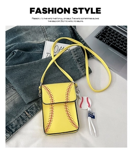 Close-up of yellow baseball-themed crossbody bag with red stitching and a round charm