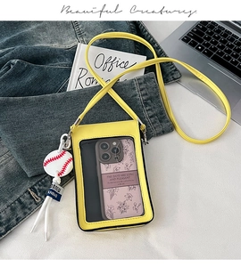 Macro detail of yellow phone bag with transparent touch screen window and baseball charm