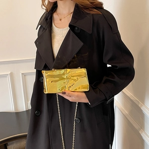 Elegante borsa a tracolla dorata plissettata metallizzata indossata da una modella