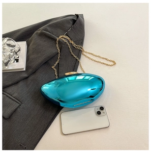 Metallic blue acrylic clutch bag with gold chain strap shown next to a smartphone for size