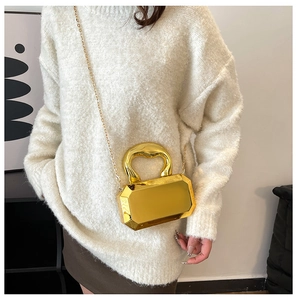 Detailed view of golden geometric mirrored box bag with thick chain handle