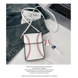 Detailed view of white baseball-themed crossbody bag with red stitching and small pendant