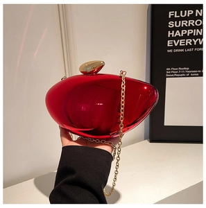 Close-up of vibrant red metallic mango-shaped evening clutch with gold chain strap
