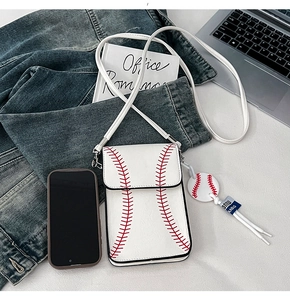 Detailed view of baseball style shoulder bag with red stitching and small round charm